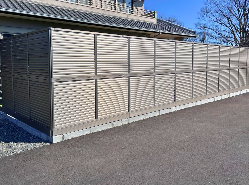 隙間のないルーバータイプのフェンスを2段重ねにし、高さ2mの空間を確保。